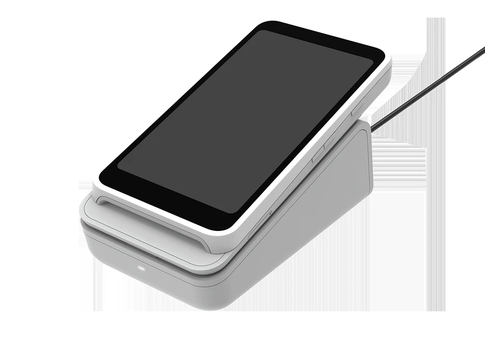 A card reader with a touchscreen resting on its charging dock
