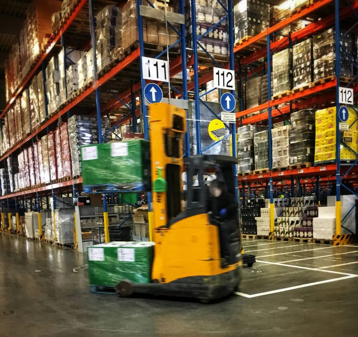 A wholesale warehouse with a forklift moving pallets